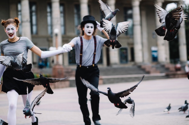 Pigeons volants devant couple mime en cours d&#39;exécution