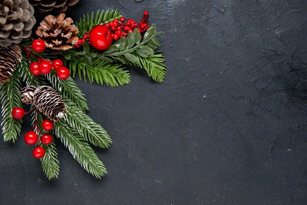 Pignons de pin avec des décorations rouges comme concept de Noël sur fond gris
