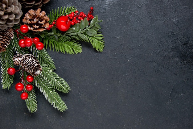 Pignons de pin avec des décorations rouges comme concept de Noël sur fond gris