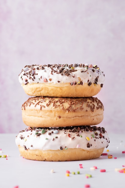 Pile de beignets avec différents vitrages et paillettes