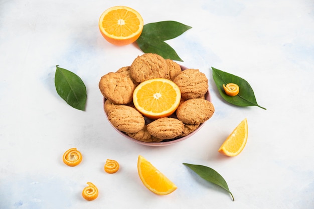 Pile de biscuits frais faits maison avec des tranches d'orange.