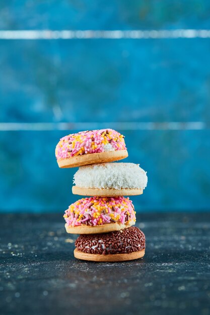 Pile de biscuits gonflés colorés sur mur bleu.