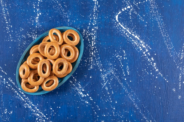 Photo gratuite pile de bretzels ronds salés placés sur la plaque bleue