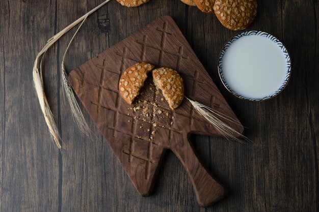 Pile de délicieux biscuits avec des céréales et un bol de lait frais.