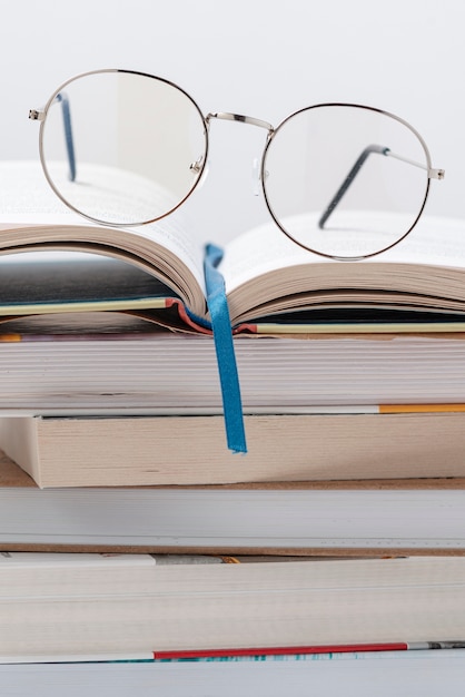 Pile de livres à angle bas avec des lunettes sur le dessus