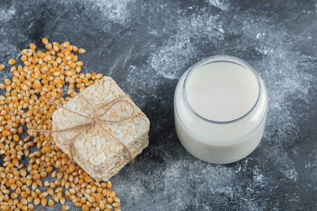 Photo gratuite pile de pain croustillant et verre de lait sur marbre.