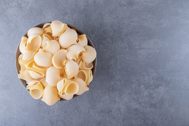 Pile de pâtes conchiglie dans une tasse classique.