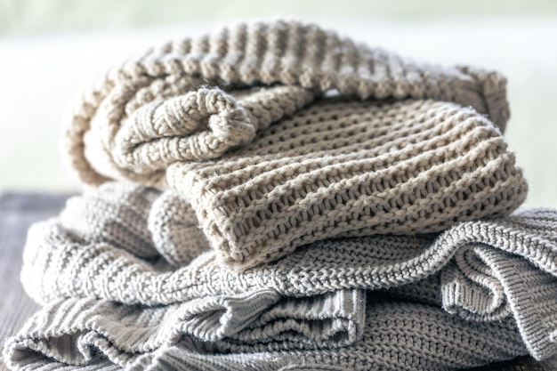 Photo gratuite une pile de pulls tricotés confortables sur fond de bois