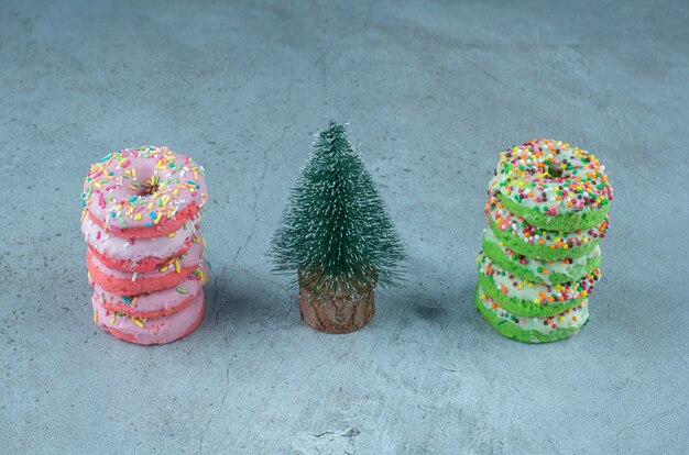 Des piles de beignets et une figurine d'arbre sur marbre.