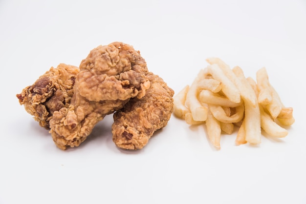 Pilon de poulet frit avec des frites sur fond blanc