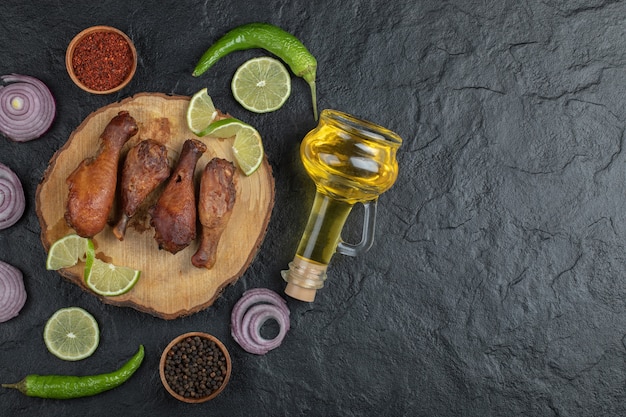 Pilon de poulet grillé avec légumes sur planche de bois.