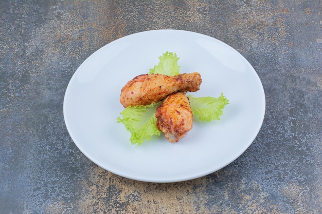 Pilons de poulet grillés sur assiette avec laitue. photo de haute qualité