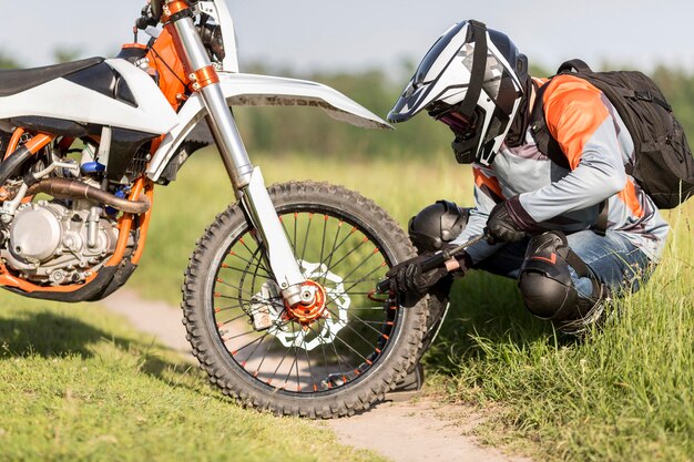 Pilote élégant vérifiant la pression des roues