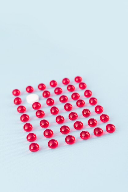 Pilule blanche en motif de boules rouges