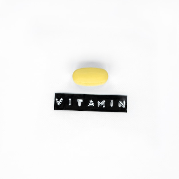 Pilule de vitamine jaune isolé sur fond blanc