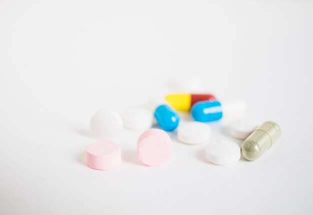 Pilules colorées et capsules sur fond blanc