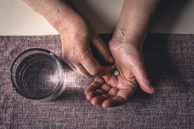 Photo gratuite pilules dans les mains d'une vieille femme vue de dessus