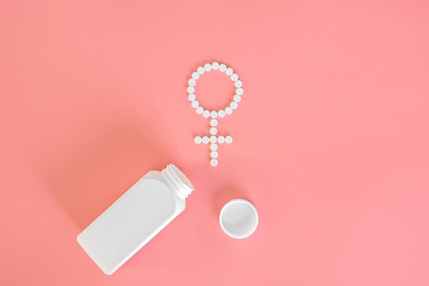 Pilules sur fond rose plat poser la santé des femmes
