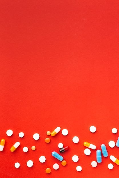 Pilules médicales colorées et fond d'espace copie rouge