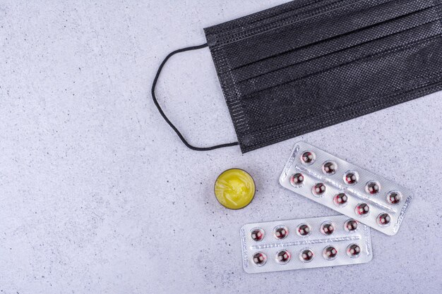 Pilules Médicales Et Masque De Protection Sur Fond De Marbre. Photo De Haute Qualité