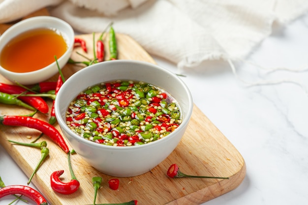 Piment Et Sauce De Poisson Sur Une Surface Blanche