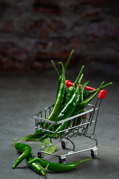 Piments frais dans un panier sur fond noir.