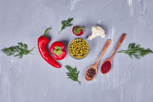 Piments rouges aux pois et épices dans des cuillères en bois.