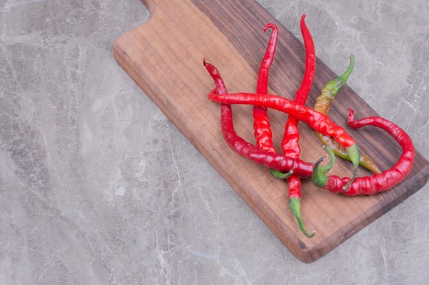 Piments Rouges Isolés Sur Un Plateau En Bois Sur Une Surface En Marbre