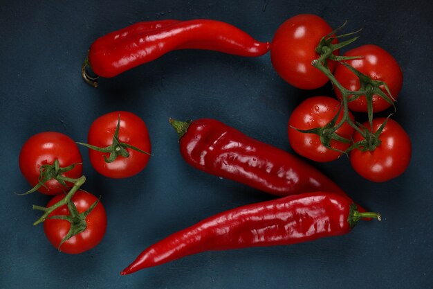 Piments rouges et tomates sur fond bleu