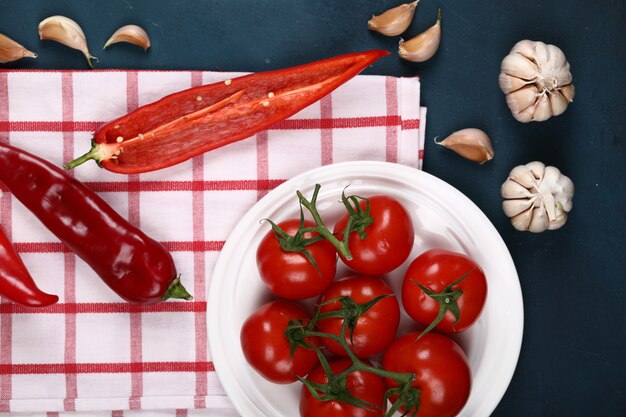 Piments, tomates et ail sur une table.