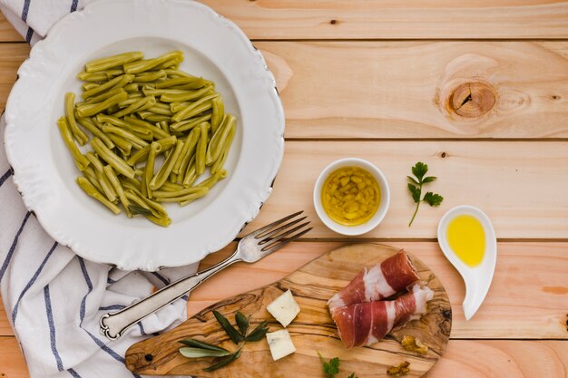 Épinards gemelli; fromage; bacon et huile infusé sur une table en bois