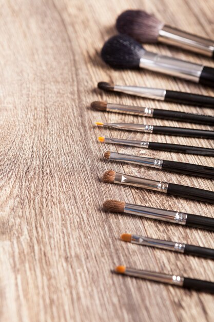 Pinceaux de maquillage professionnels sur fond en bois. Industrie de la beauté