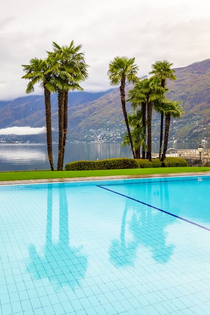 Piscine entourée de palmiers et d'un lac alpin à Ascona en Suisse