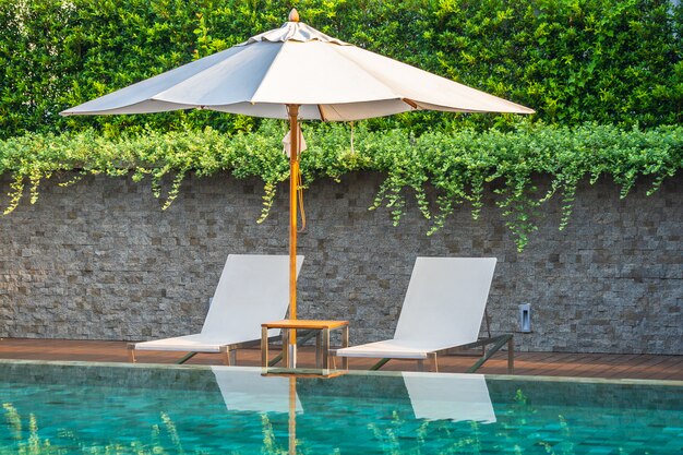 Piscine en plein air avec chaises longues et parasols pour les voyages d&#39;agrément