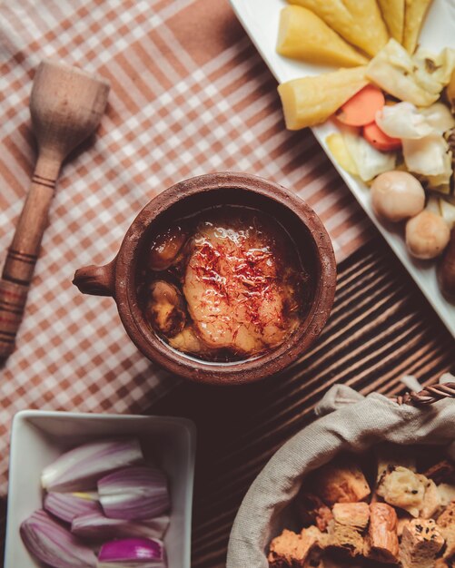 Photo gratuite piti dans un pot en argile avec des oignons