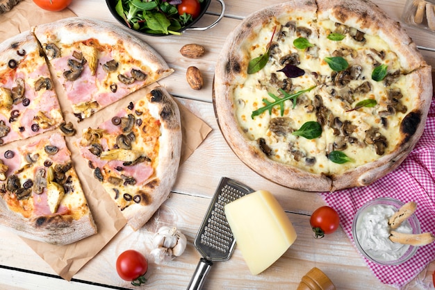 Pizza au fromage; salade au fromage; trempette et légumes sur une surface en bois