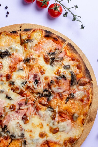 Pizza aux champignons sur le bureau avec des tomates