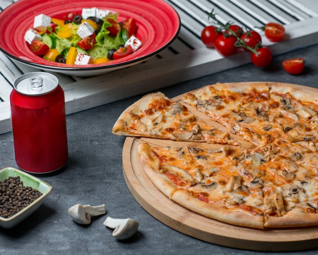 Pizza aux champignons avec salade de légumes et canette de cola