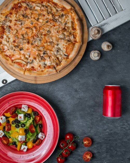 Pizza aux champignons avec salade de légumes.