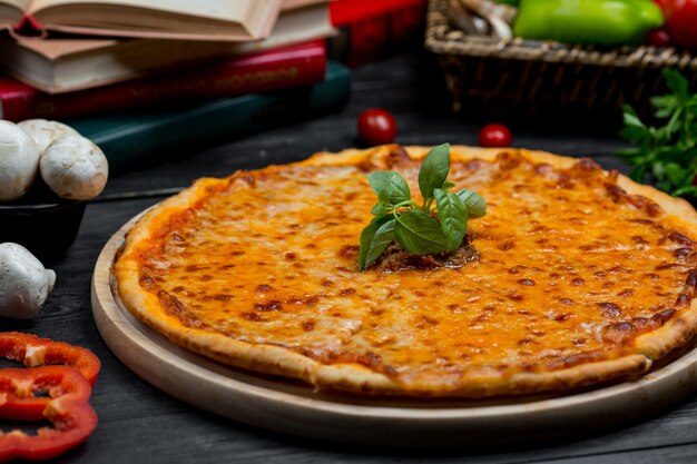 Pizza classique à la margarita avec cheddar fondu et feuilles de basilique fraîches