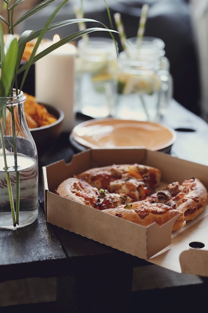 Pizza dans une boîte en carton et collations