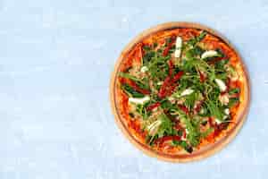Photo gratuite pizza fraîche aux herbes et tomates séchées au soleil sur table grise