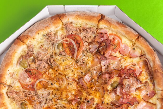 Pizza à l'intérieur de l'emballage sur la table verte