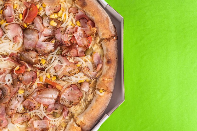 Pizza à l'intérieur de l'emballage sur la table verte