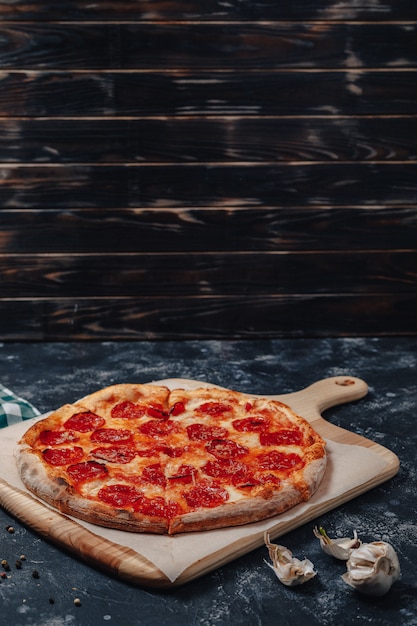 Pizza napolitaine appétissante sur un tableau noir avec divers ingrédients, espace libre pour le texte