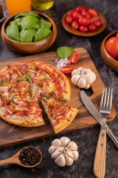 Pizza posée sur une assiette en bois.