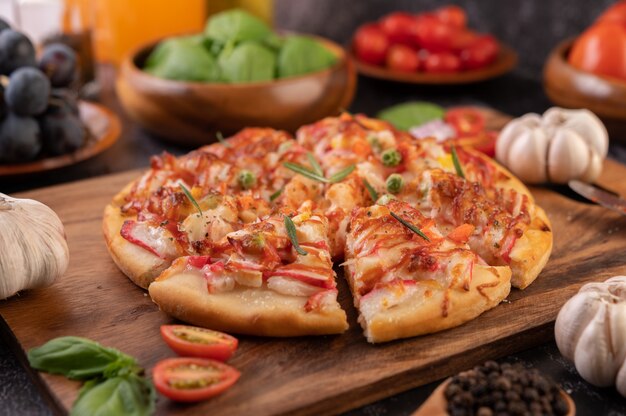 Pizza posée sur une assiette en bois.