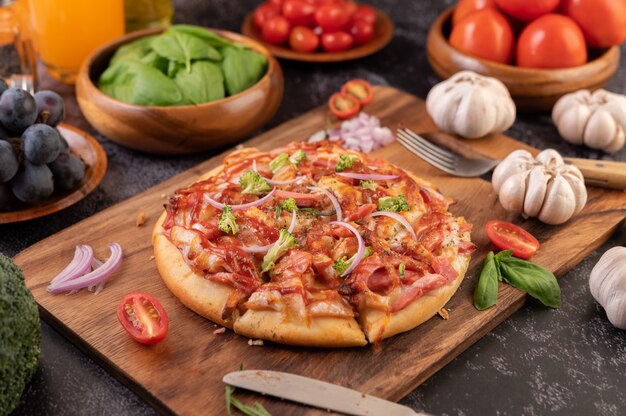 Pizza posée sur une assiette en bois.