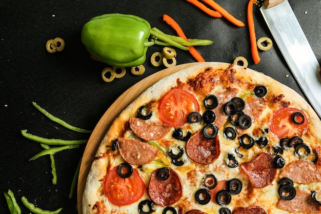 Pizza salami olives fromage tomate poivron vue latérale