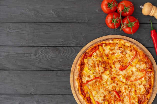 Pizza savoureuse sur la vue de dessus de fond en bois noir